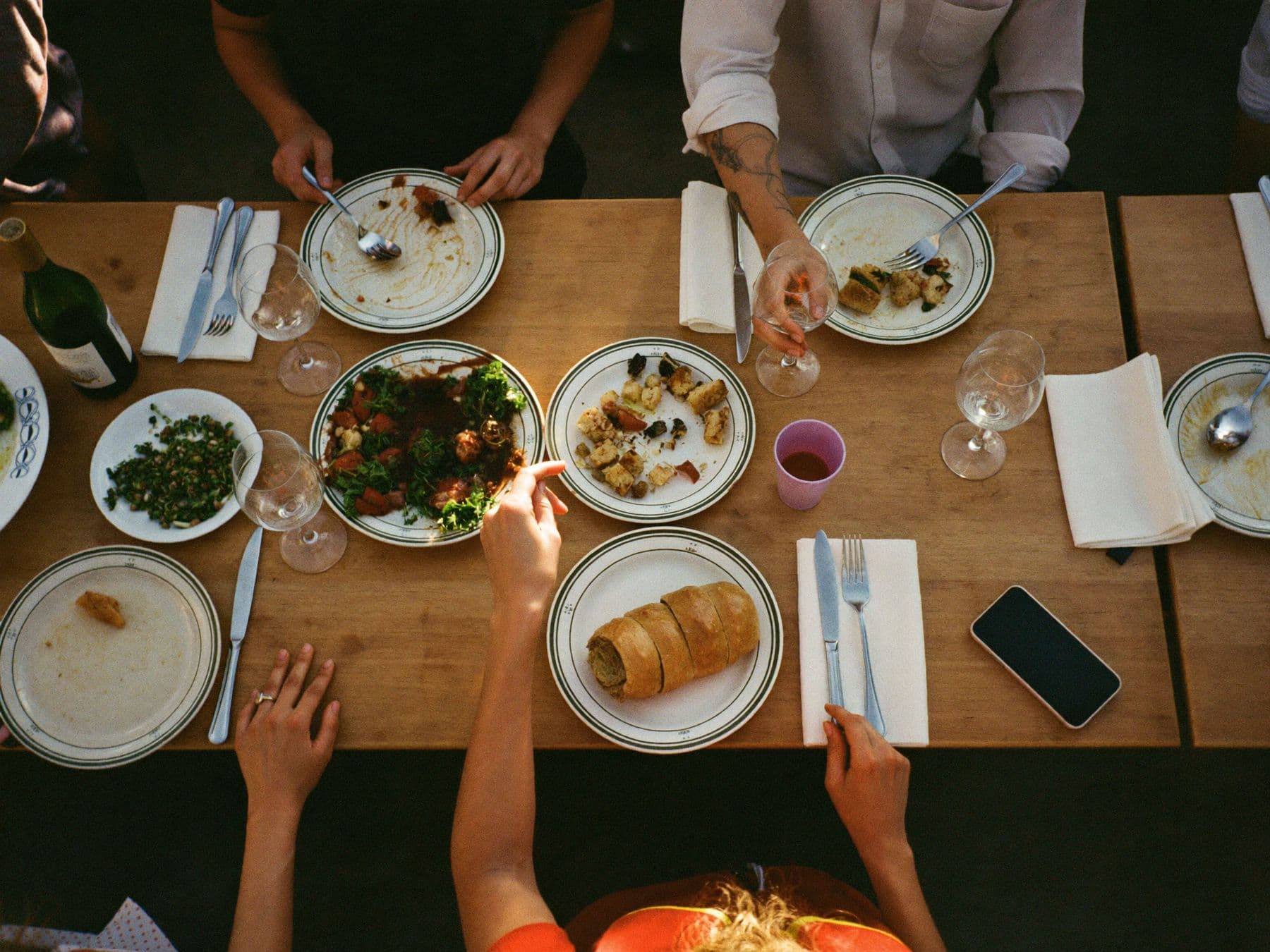 Friends sharing dinner around a wooden table